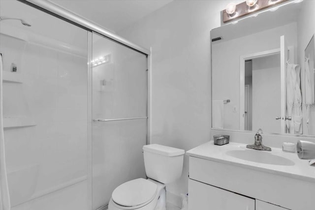 bathroom featuring an enclosed shower, vanity, and toilet