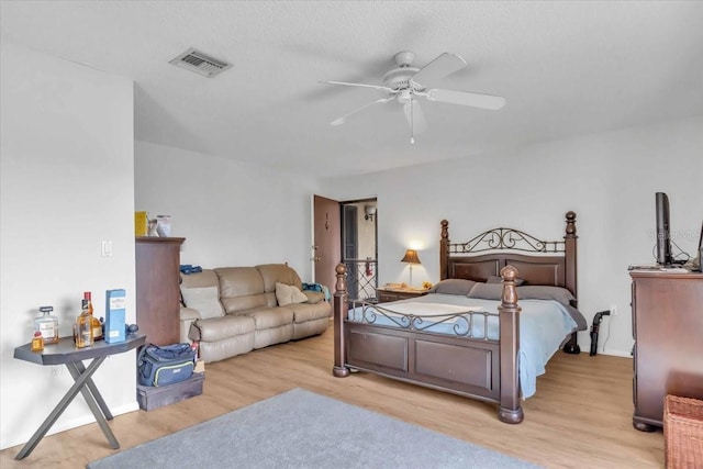 bedroom with light wood-type flooring, a textured ceiling, and ceiling fan