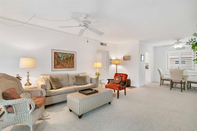 living room featuring ceiling fan, crown molding, and light carpet