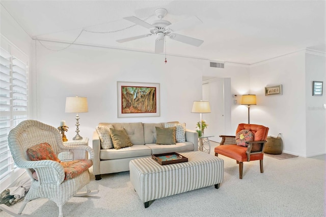 carpeted living room featuring ceiling fan and ornamental molding