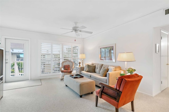 carpeted living room with ceiling fan