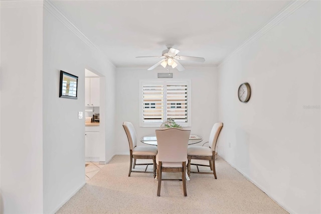 dining room featuring crown molding, light colored carpet, and ceiling fan