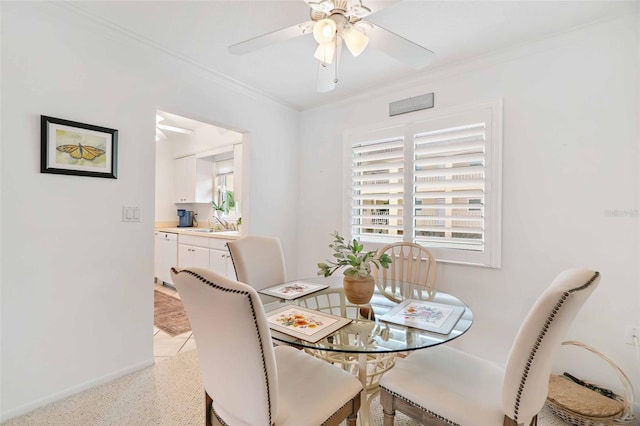 dining room with ceiling fan, sink, and ornamental molding