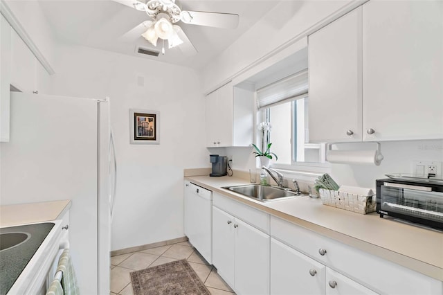 kitchen with white appliances, white cabinets, sink, and light tile patterned floors