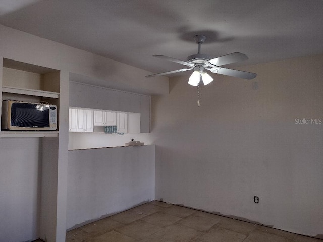 1801 Gulf Dr N Unit 121, Bradenton Beach, FL 34217 - kitchen with a ceiling fan and white cabinets