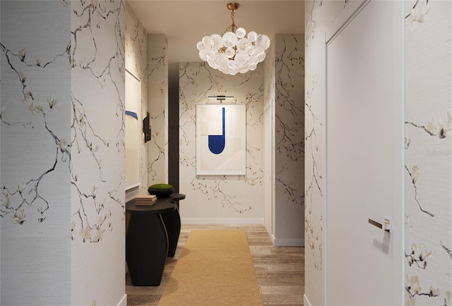 hallway featuring a chandelier and light hardwood / wood-style flooring