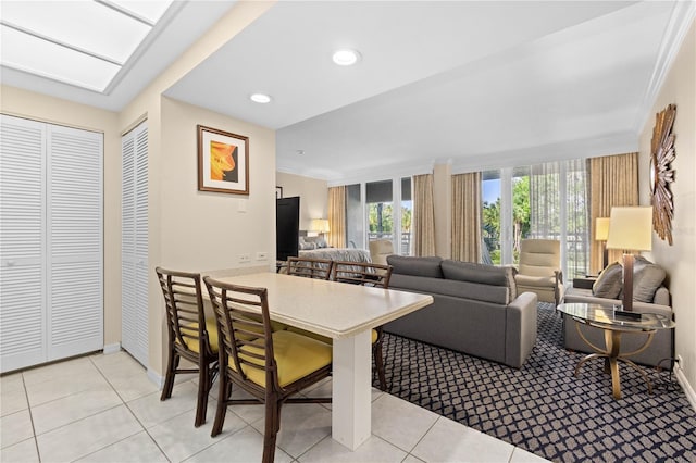 tiled living room with ornamental molding and a skylight