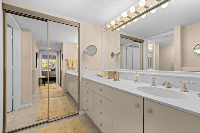 bathroom featuring vanity, tile patterned floors, and a textured ceiling