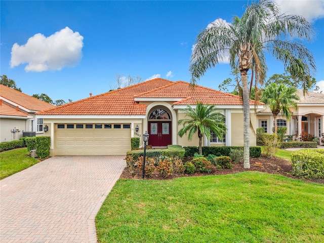 mediterranean / spanish-style home with a garage and a front yard