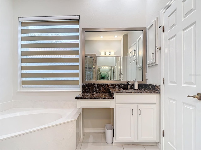 bathroom with a healthy amount of sunlight, tile patterned floors, independent shower and bath, and vanity