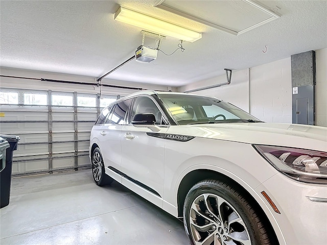 garage with a garage door opener and electric panel