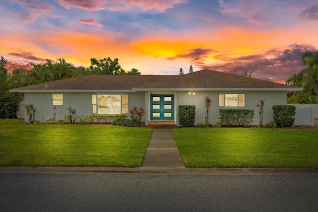 single story home with a lawn