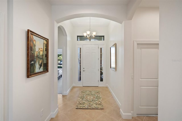 entryway featuring plenty of natural light, a chandelier, and light tile patterned floors