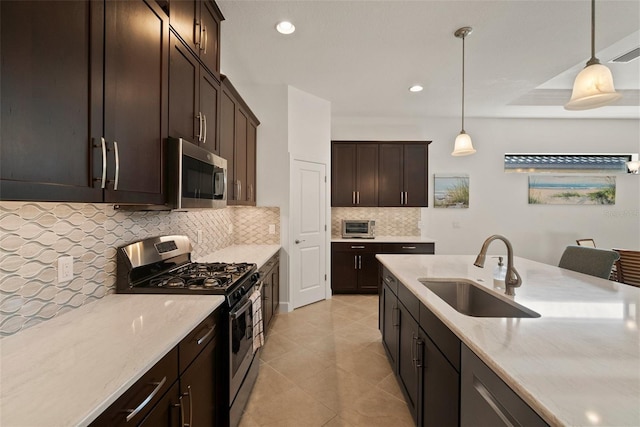 kitchen with sink, decorative backsplash, hanging light fixtures, stainless steel appliances, and dark brown cabinets