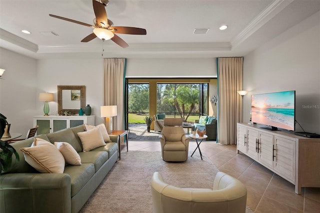 tiled living room featuring crown molding, a tray ceiling, and ceiling fan