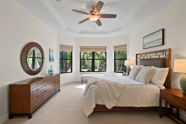 carpeted bedroom featuring a raised ceiling, crown molding, and ceiling fan