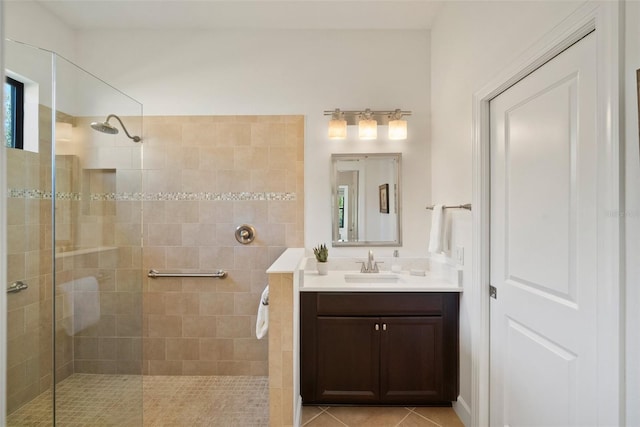 bathroom with vanity, tile patterned flooring, and tiled shower