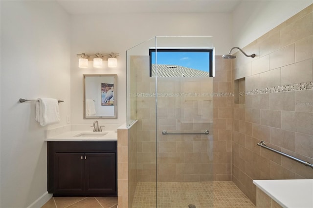 bathroom featuring tile patterned flooring, vanity, and a tile shower