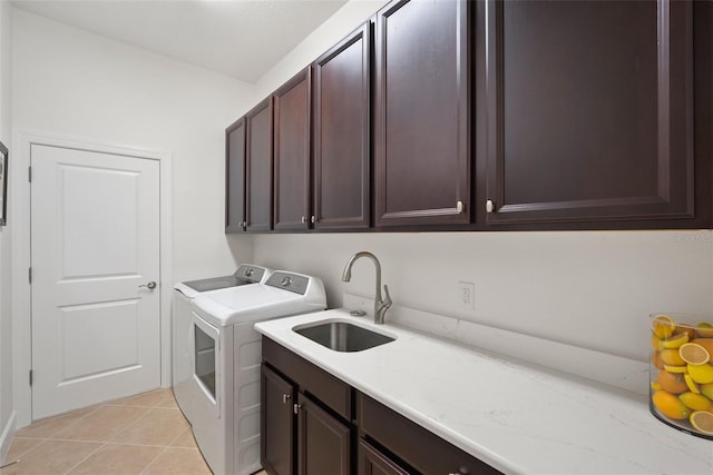 washroom with cabinets, washing machine and dryer, sink, and light tile patterned flooring