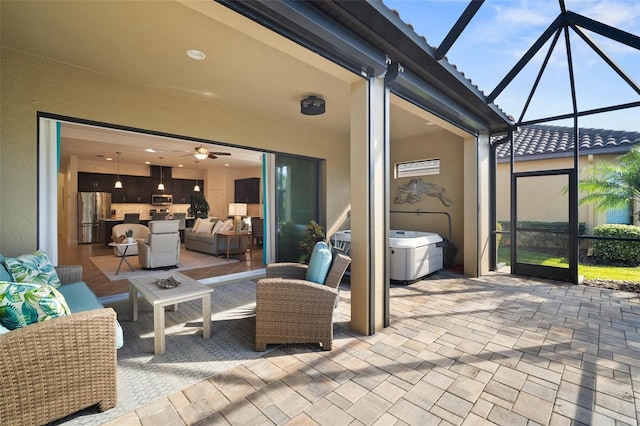 view of patio featuring ceiling fan, an outdoor living space, and a lanai