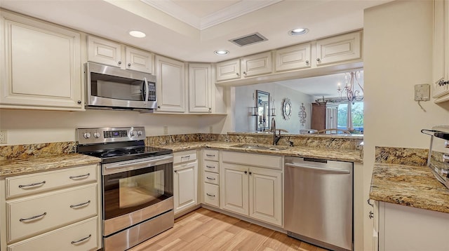 kitchen featuring sink, ornamental molding, stainless steel appliances, light stone countertops, and light hardwood / wood-style floors