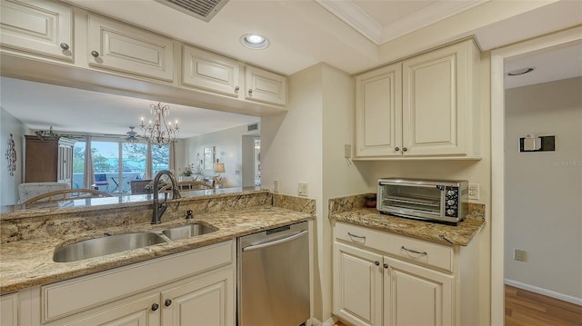 kitchen featuring sink, light stone countertops, cream cabinetry, and dishwasher