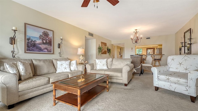 living room with ceiling fan with notable chandelier and light colored carpet