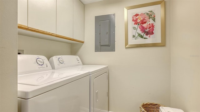 laundry room with separate washer and dryer, electric panel, and cabinets