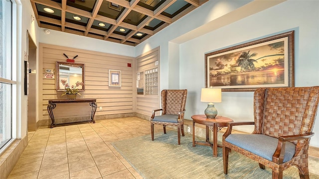 living area with light tile patterned flooring, coffered ceiling, and beam ceiling