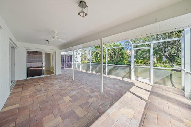 unfurnished sunroom featuring ceiling fan