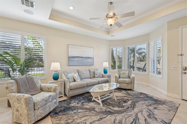 living room featuring ornamental molding, plenty of natural light, ceiling fan, and a tray ceiling