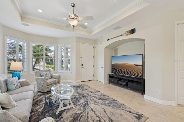 living room with light tile patterned floors, crown molding, and a raised ceiling