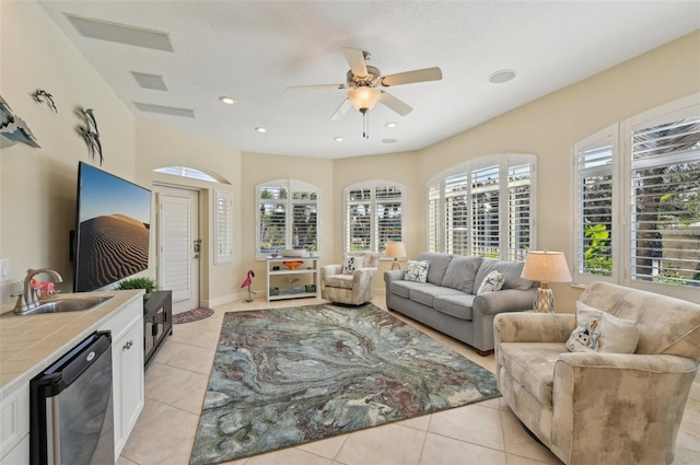 living room featuring sink, ceiling fan, and light tile patterned flooring