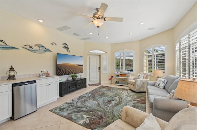 living room featuring ceiling fan, sink, and light tile patterned floors