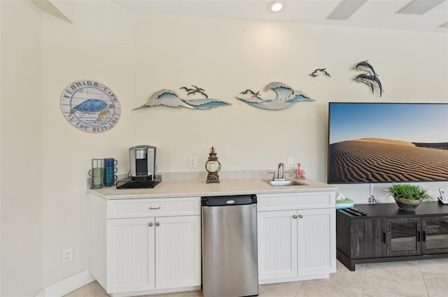 kitchen featuring light tile patterned floors, sink, and white cabinets