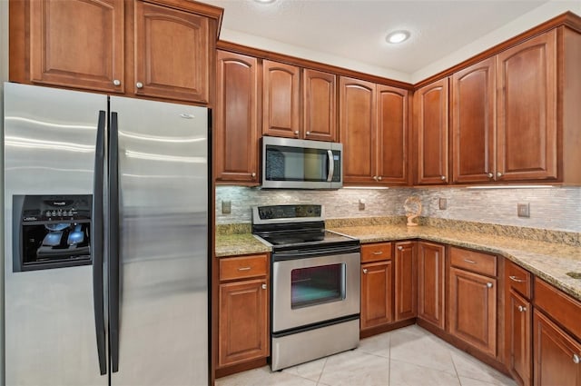 kitchen featuring light tile patterned floors, decorative backsplash, light stone countertops, and appliances with stainless steel finishes