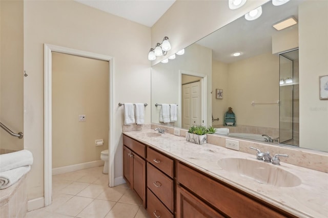 bathroom with tile patterned flooring, vanity, a tub, and toilet