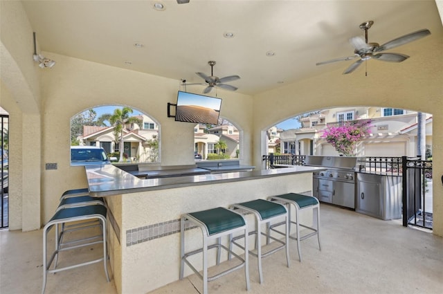 view of patio featuring area for grilling, an outdoor bar, and ceiling fan