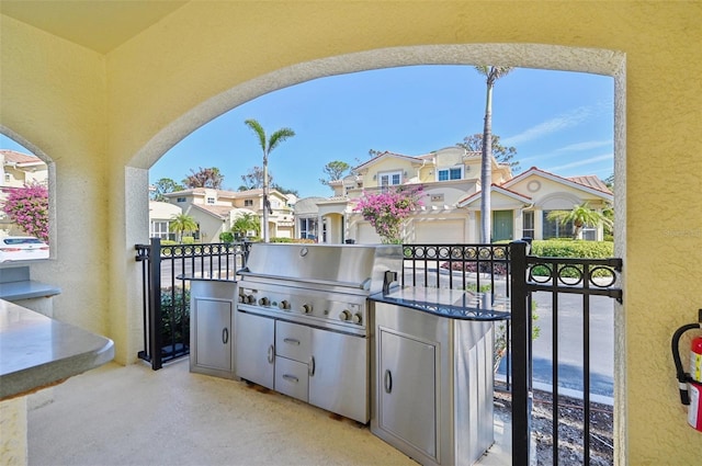 view of patio with a grill, a balcony, and exterior kitchen