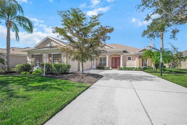 single story home with a garage, a front lawn, and french doors