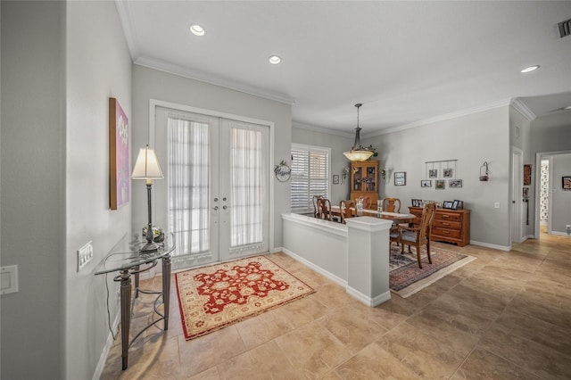 foyer entrance with ornamental molding and french doors