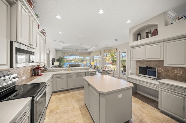 kitchen featuring appliances with stainless steel finishes, a center island, gray cabinetry, and backsplash