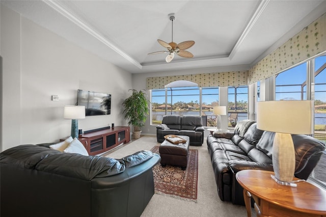 carpeted living room featuring a raised ceiling and ceiling fan