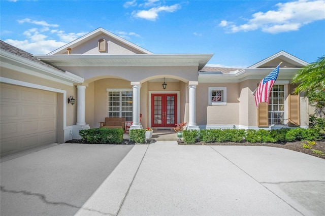 view of front of home featuring french doors, a porch, and a garage