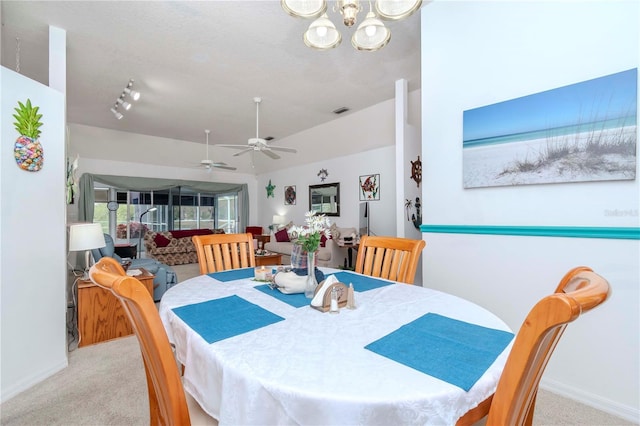 dining area with light colored carpet, ceiling fan with notable chandelier, and a textured ceiling