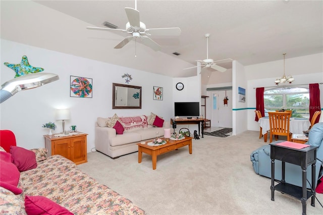 carpeted living room with lofted ceiling and ceiling fan with notable chandelier