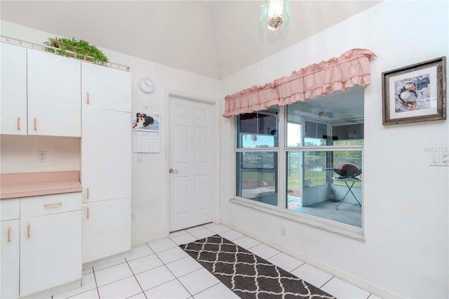 kitchen featuring light tile patterned floors and white cabinets