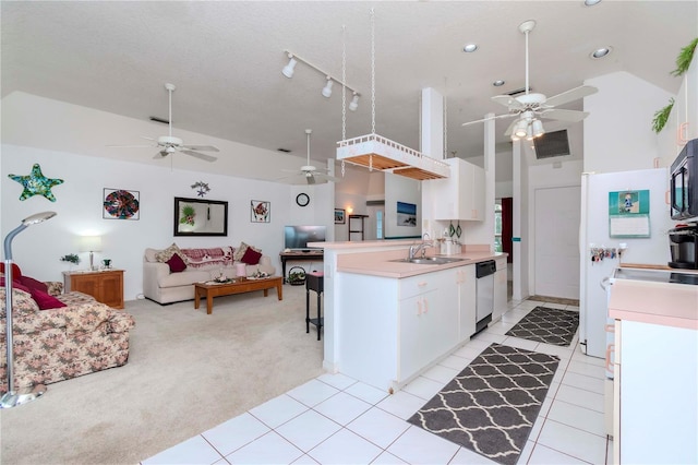 kitchen with appliances with stainless steel finishes, white cabinetry, sink, light colored carpet, and kitchen peninsula