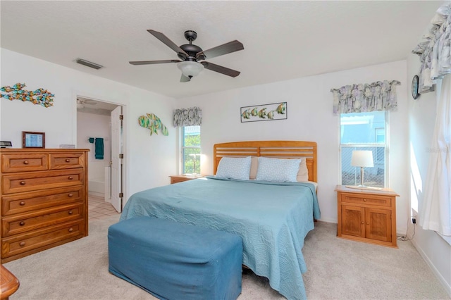 carpeted bedroom featuring ceiling fan and ensuite bath