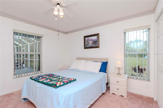 carpeted bedroom featuring ceiling fan and ornamental molding